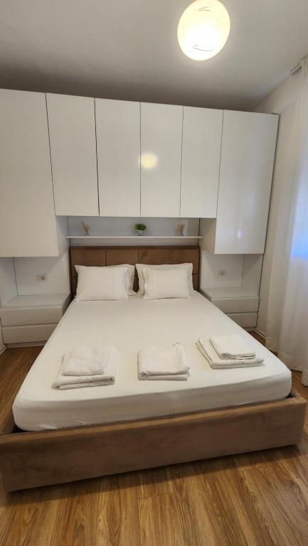 a large bed with white cabinets on top of it at Seasons Apartment's Vlora in Vlorë