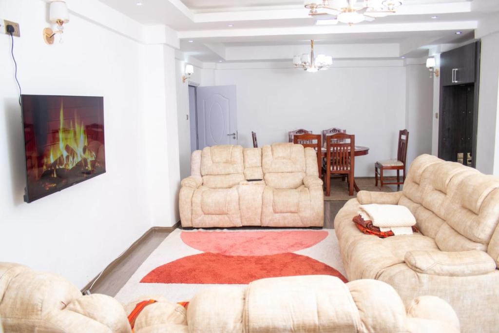 sala de estar con 2 sillas y sofá en 4bedroom Navilla westlands Nairobi, en Nairobi