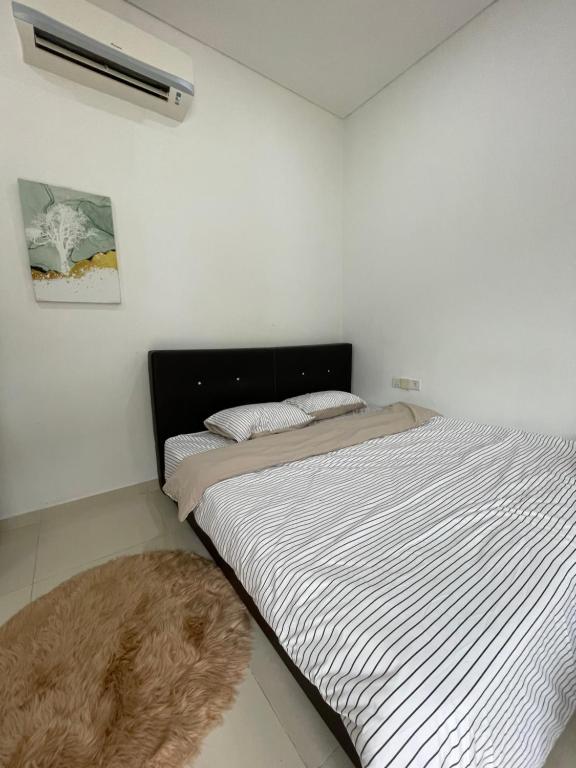 a bedroom with a bed with a black and white comforter at Plaza Arkadia in Desa ParkCity in Kuala Lumpur