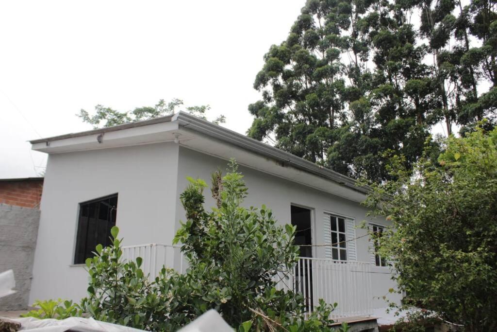uma casa branca com árvores em frente em Pousada da Vovó (Nelci) em Ponta Grossa