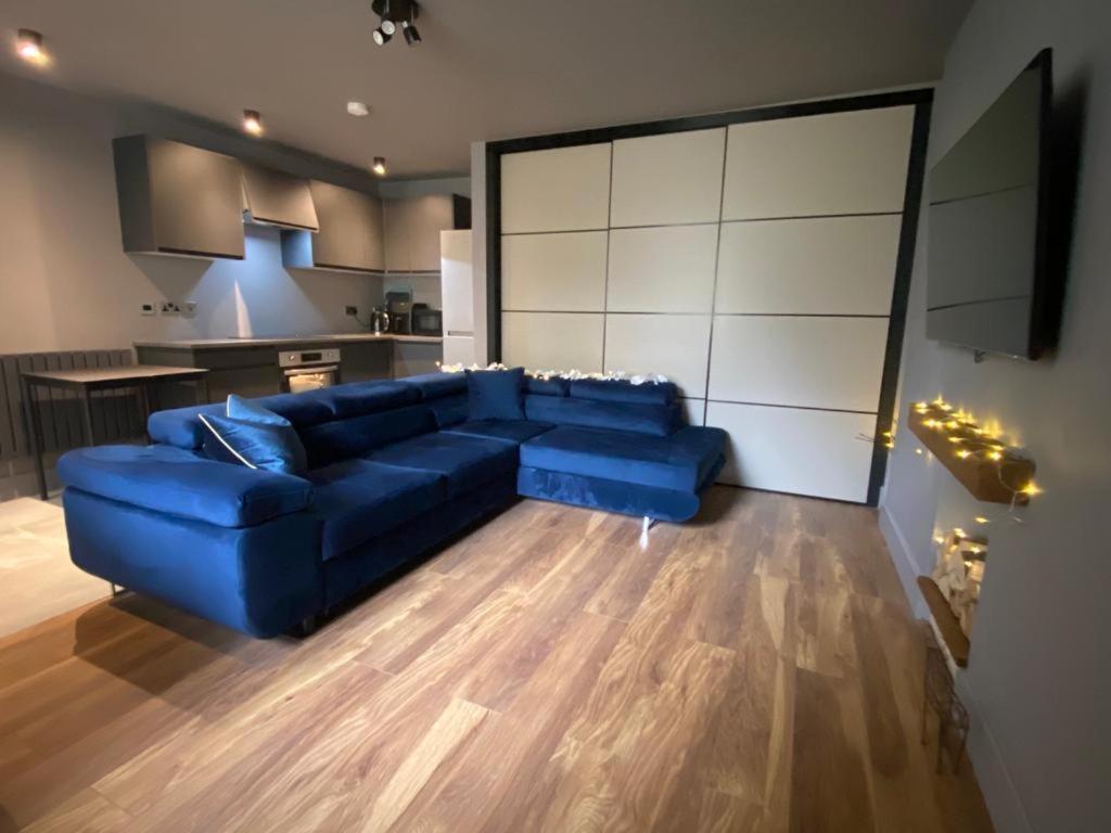 a living room with a blue couch and a kitchen at RRM Studio 