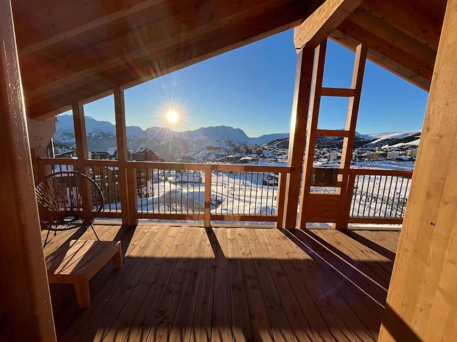 a wooden porch with a bench and a view of the mountains at La Terrasse de l Alpe d Huez in L'Alpe-d'Huez
