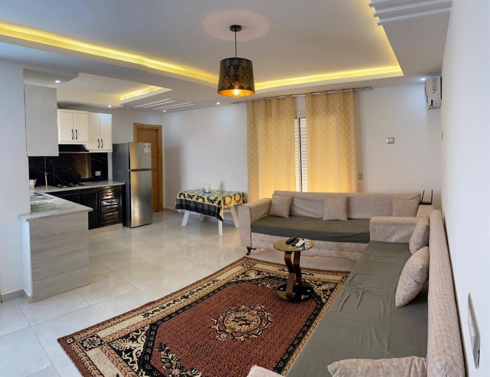 Il comprend un salon avec un canapé et une cuisine. dans l'établissement Dar sammoud S+1, à Kelibia