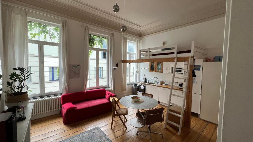 salon z czerwoną kanapą i stołem w obiekcie Arti Appart Louise/Flagey/Centre w Brukseli
