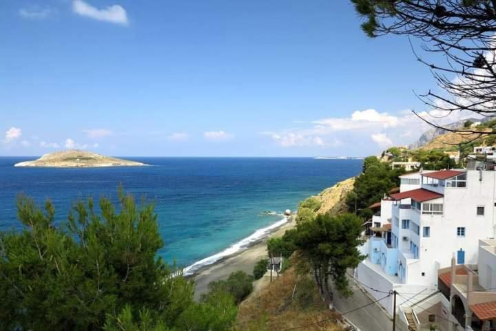 - une vue sur la plage avec des maisons et l'océan dans l'établissement Kalymnos Platy Gialos Mousellis Makis Apartments, à Kalymnos