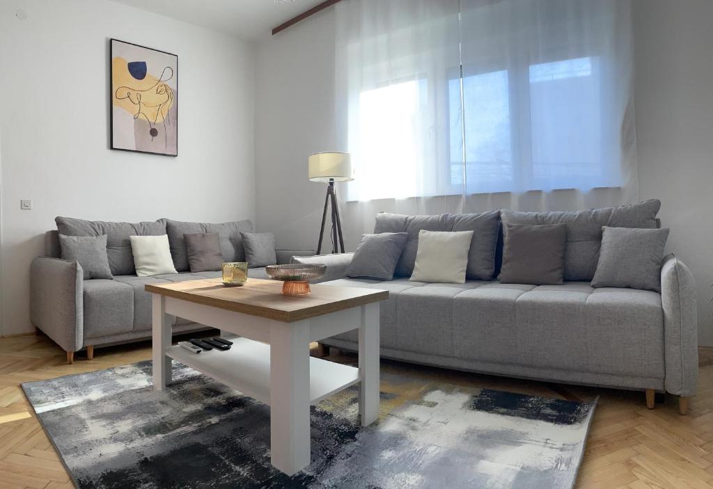 een woonkamer met een bank en een tafel bij Apartman Noel Knin in Knin