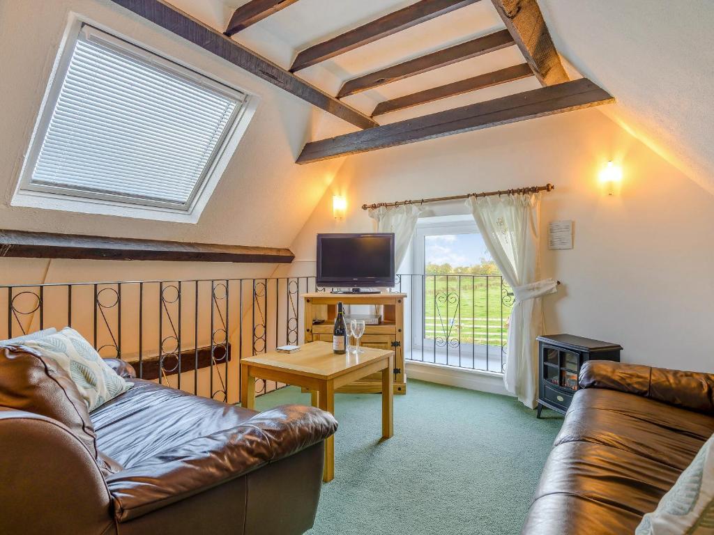 a living room with a couch and a tv at Apple Cottage-uk37361 in Lympsham