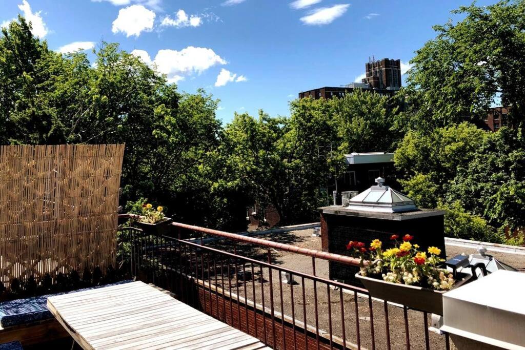 a balcony with a black fence and flowers on it at Montpetit condo 2 chambres in Montréal