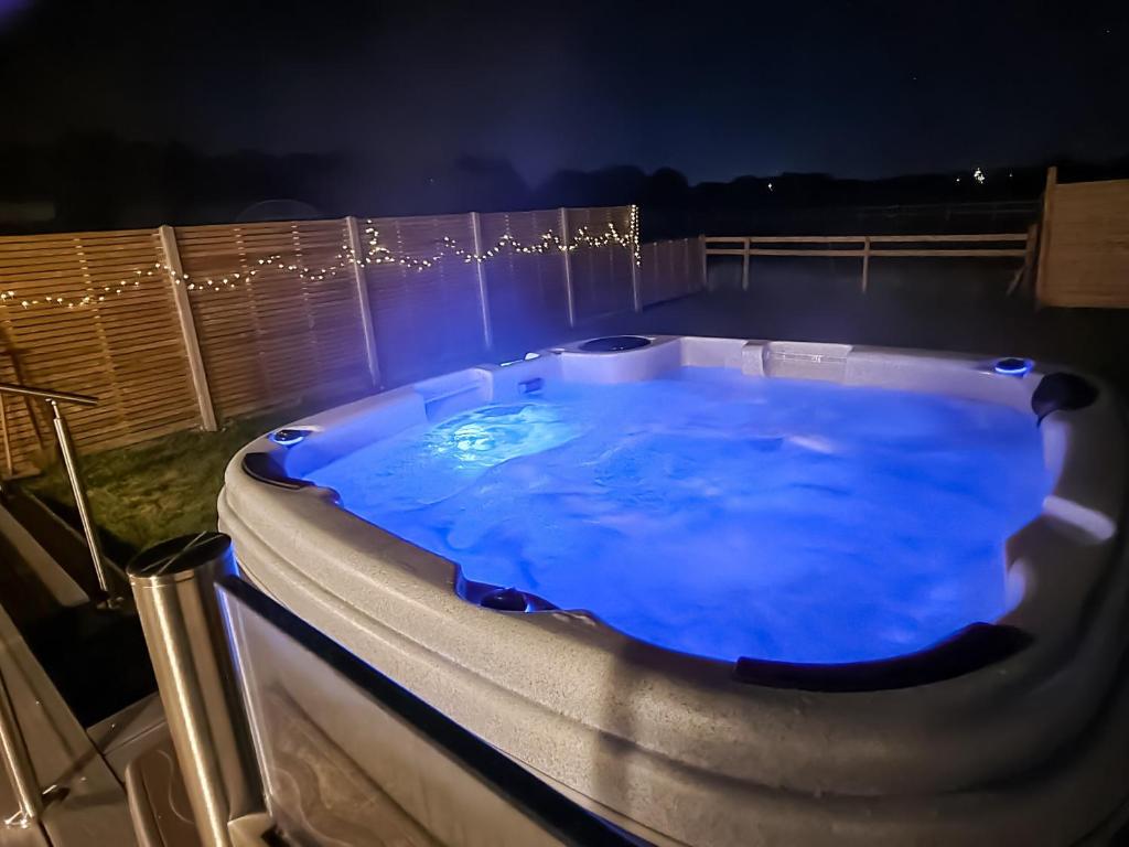 a jacuzzi tub with blue lighting on a deck at Belvedere in Corfe Mullen