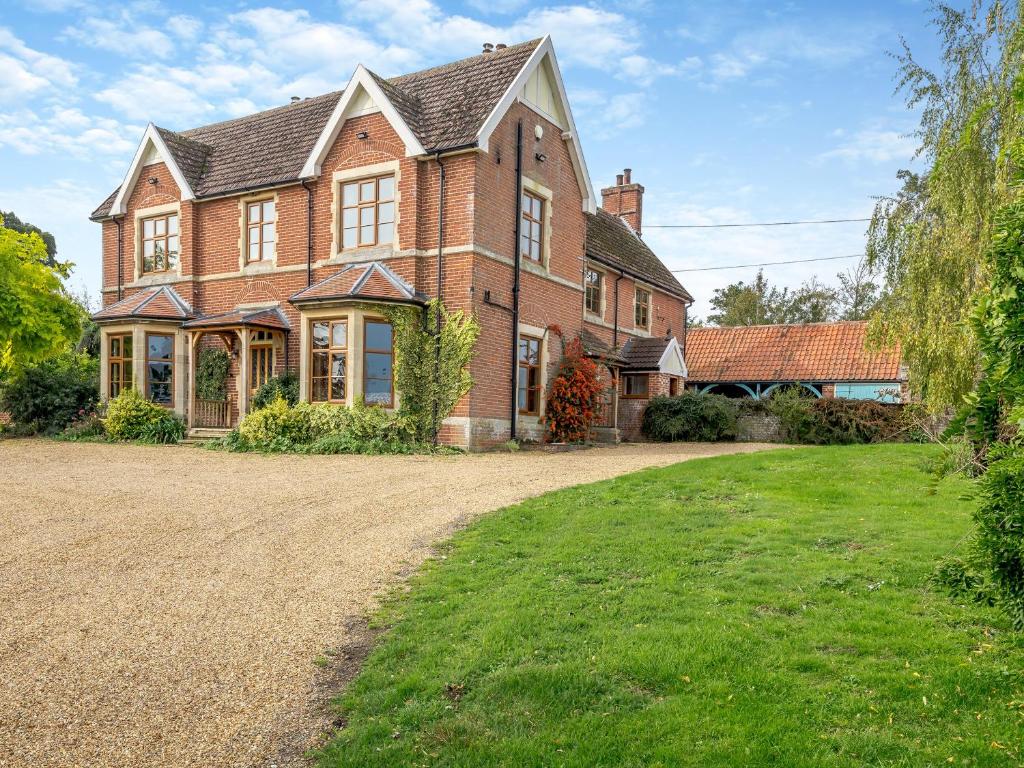 a large brick house with a gravel driveway at The Dukes Lodge 