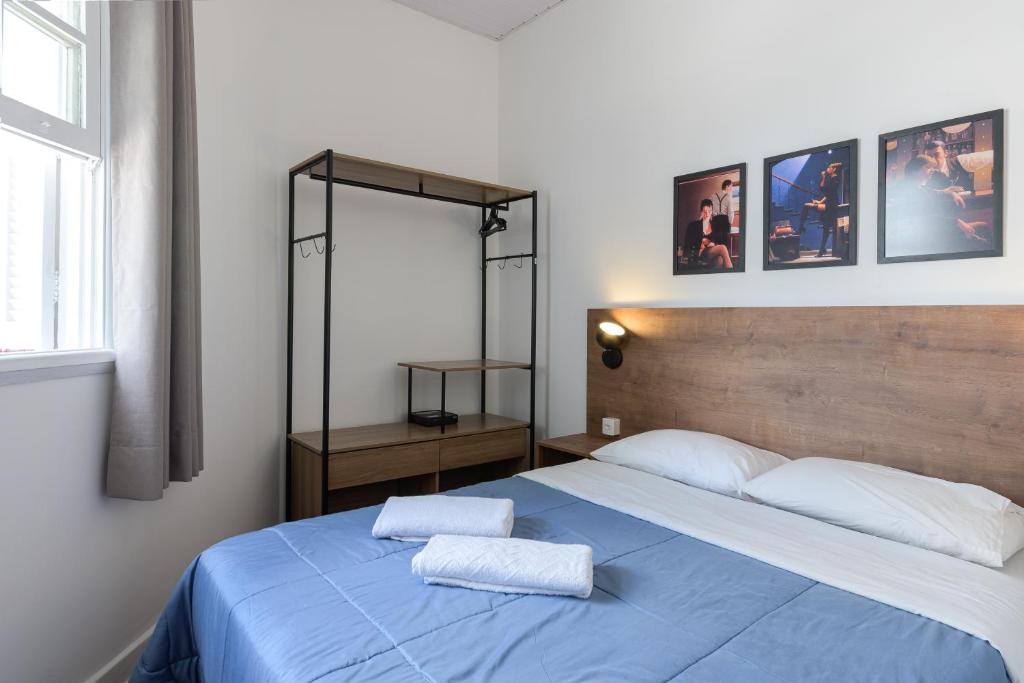 1 dormitorio con 1 cama azul y 2 toallas en Sobrado 2 dormitórios no Tatuapé, en São Paulo