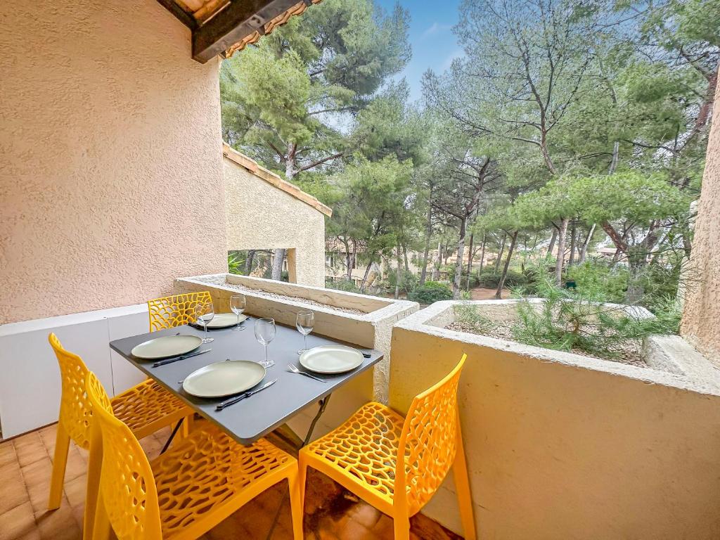 une table et des chaises sur le balcon d'une maison dans l'établissement Villa Bandolaise - 10 min de la plage, à Bandol