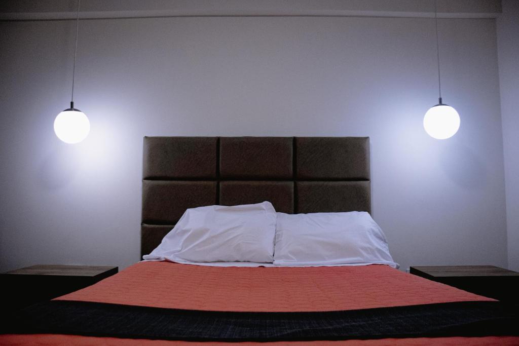 een slaapkamer met een bed met twee lampen erboven bij PRANA HOTEL LOUNGUE BAR in Huancayo
