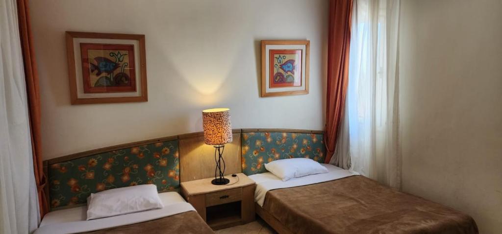 um quarto com duas camas e um candeeiro em First Class at Naama Bay Hotel Appartments em Sharm el Sheikh