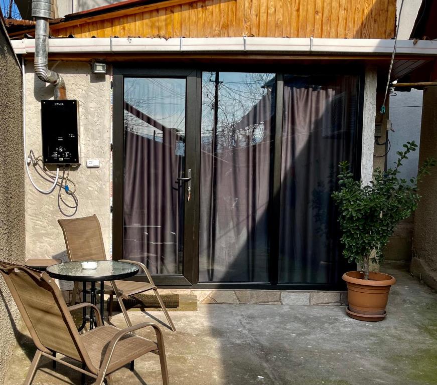 d'une terrasse avec une table et des chaises devant une fenêtre. dans l'établissement Apartment LINIMA, à Tbilissi