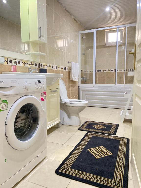 een wasmachine in een badkamer met een toilet bij Zerrin Hanım Apartments - 1 minute from Kleopatra Beach in Alanya