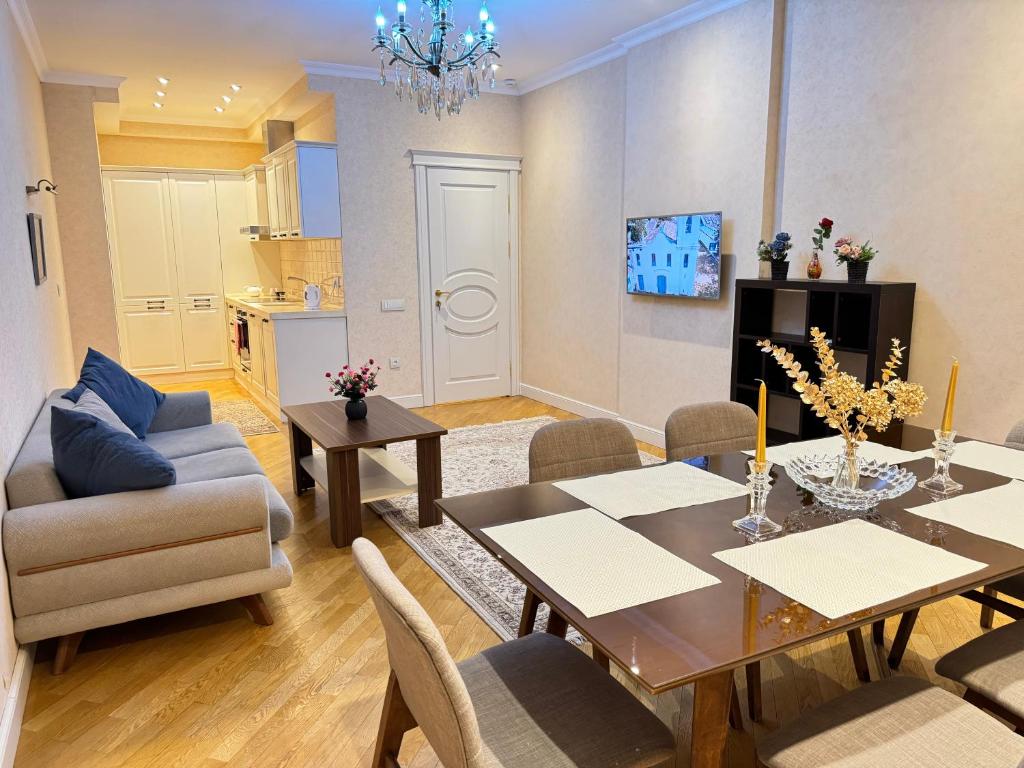 een woonkamer met een eettafel en stoelen bij Park Azure nice apartment by Baku Housing in Baku