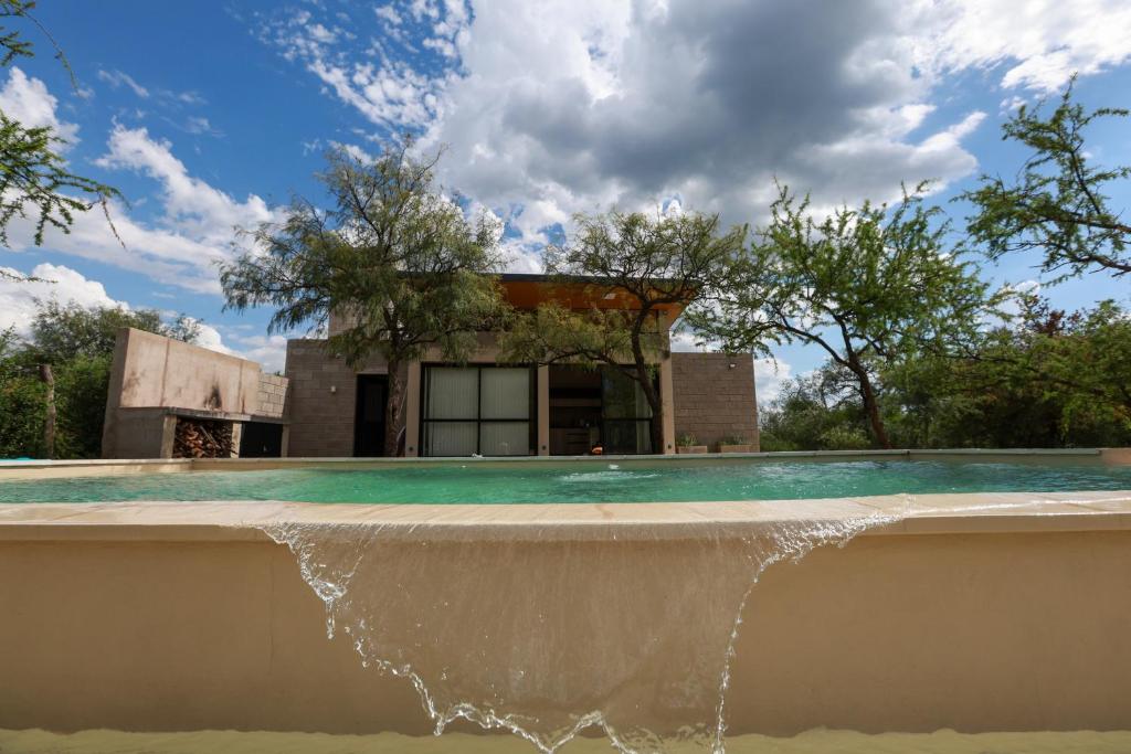 una fuente de agua frente a una casa en Quincho de las rosas solo para pasar el dia no para dormir, en ese caso hablar con encargado en Villa Las Rosas