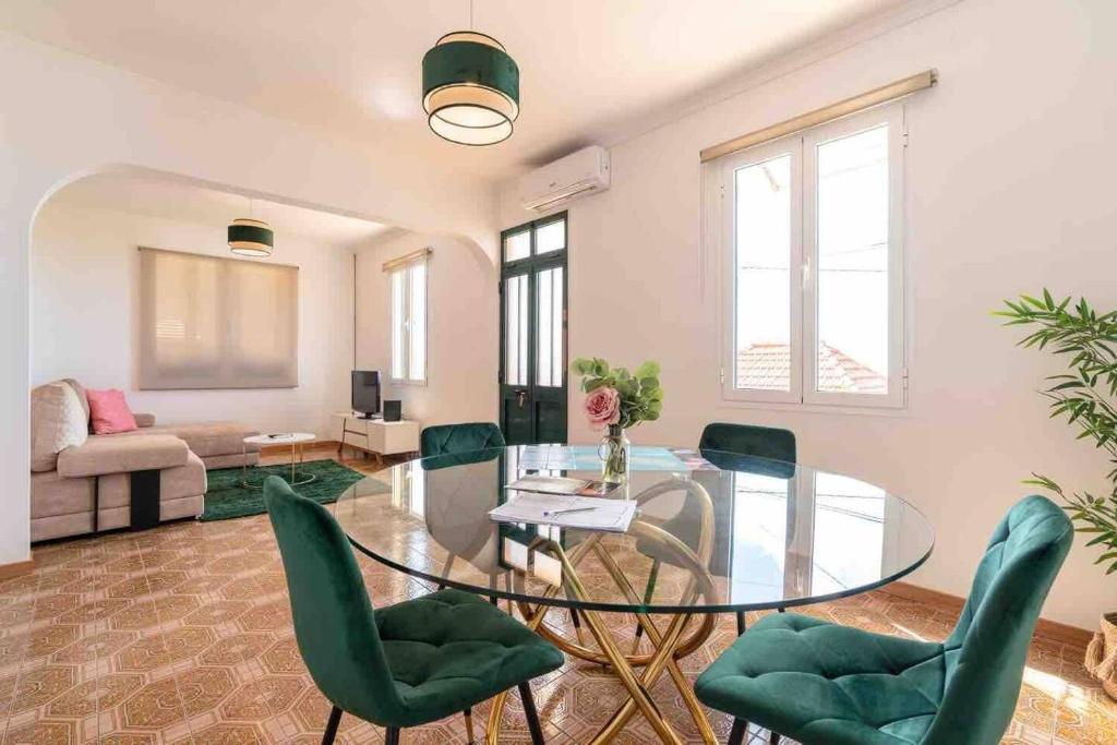 a living room with a glass table and green chairs at Ponta do Sol hills view 2BR in Ponta do Sol