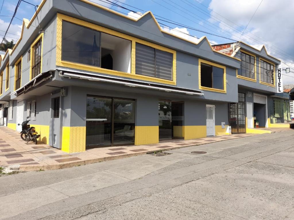 ein Gebäude mit gelber und weißer Ausstattung auf einer Straße in der Unterkunft HOTEL PARAISO DE LAS GEMELAS in Montenegro