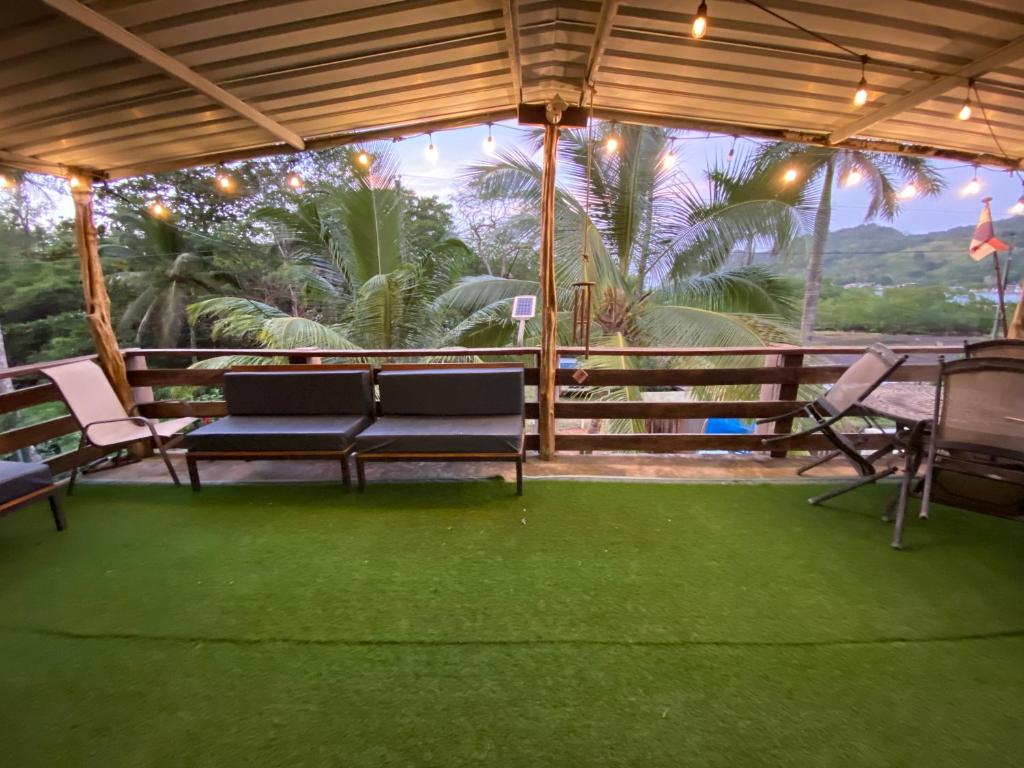 eine Terrasse mit 2 Bänken, einem Tisch und Stühlen in der Unterkunft Aeolus Guest House in José Pobre