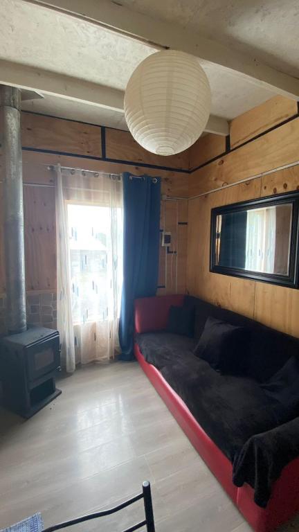 Cabaña Chaitén في شايتن: غرفة معيشة مع أريكة ونافذة