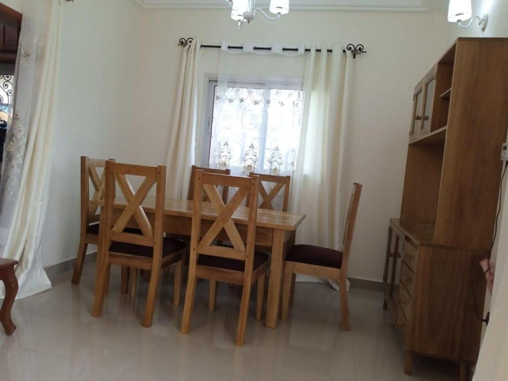 a dining room table with chairs and a window at Residence Mindja in Yaoundé