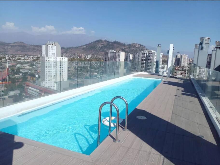 a swimming pool on the roof of a building at Apartamento en Santiago. in Santiago