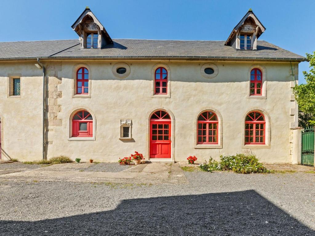 een stenen huis met rode ramen en een rode deur bij Norman manor house 8-10 pers in Saint-Martin-des-Entrées