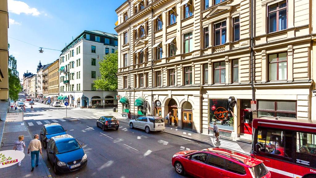 a busy city street with cars parked in front of buildings at Nomad Cave in Stockholm