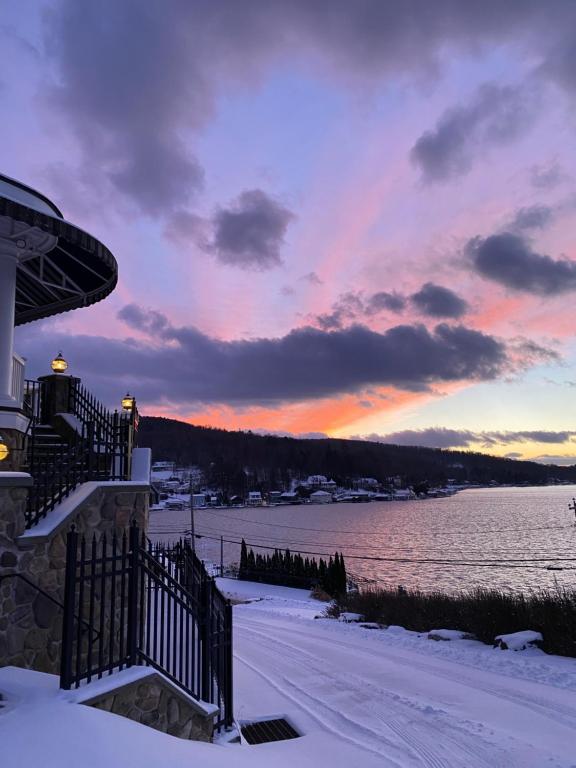a sunset over a body of water with snow at Charming & Cozy - Breathtaking Lake & Sunset Views in Harveys Lake