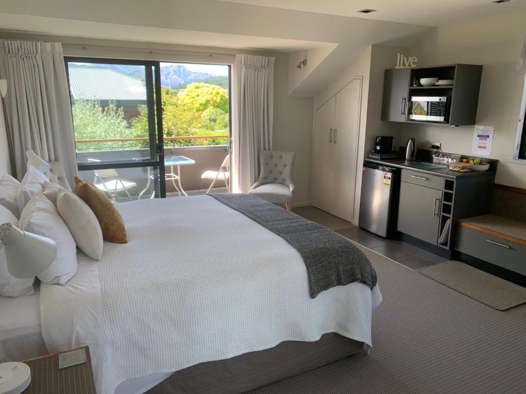 a hotel room with a large bed and a kitchen at Aspiringlofts in Wanaka