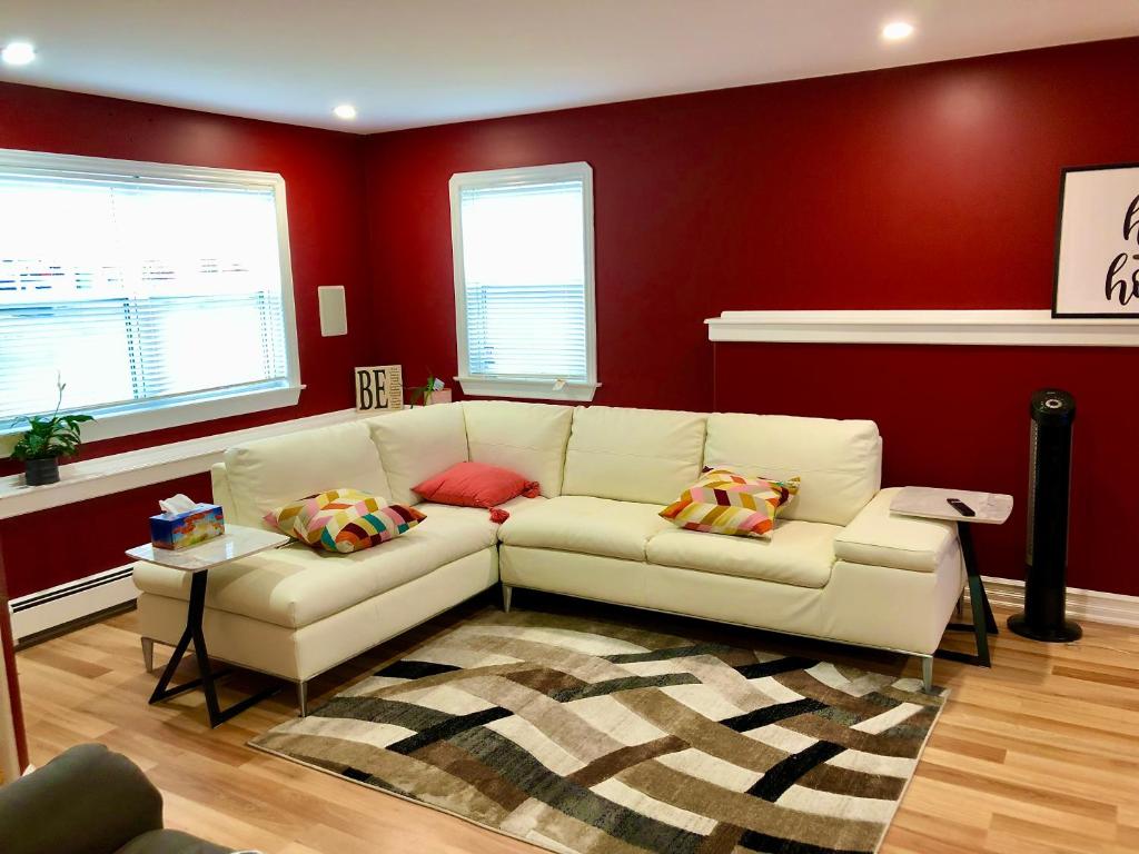 a living room with a white couch and red walls at Vito Place in Halifax