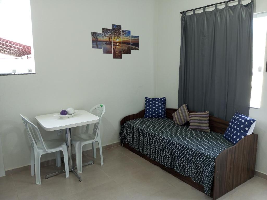 Flat Solife 3 Cabo Frio-Búzios في كابو فريو: غرفة نوم بسرير وطاولة مع كراسي