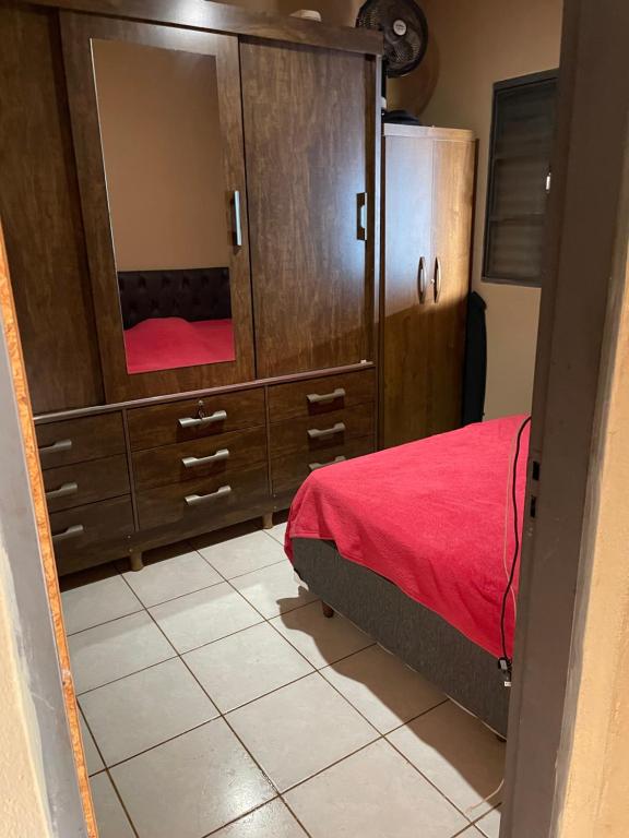 ein Schlafzimmer mit einer großen Kommode mit einem Bett und einem Spiegel in der Unterkunft Casa para temporada, Guilherme. in Vargem Bonita