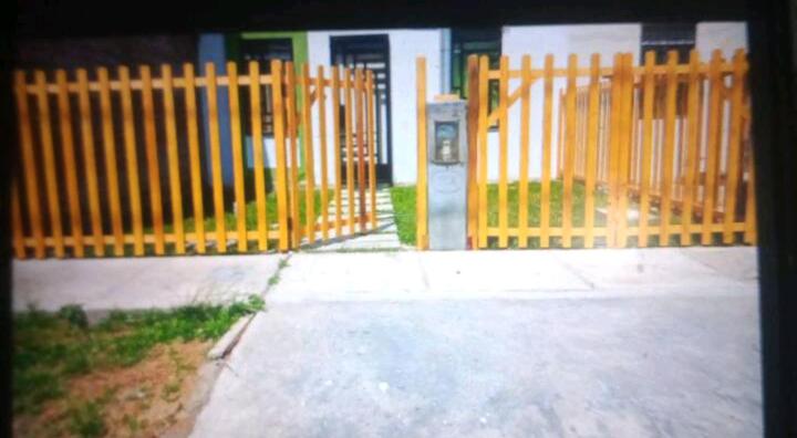 ein gelber Zaun vor einem Haus in der Unterkunft Casa acogedora y relajante in Ica