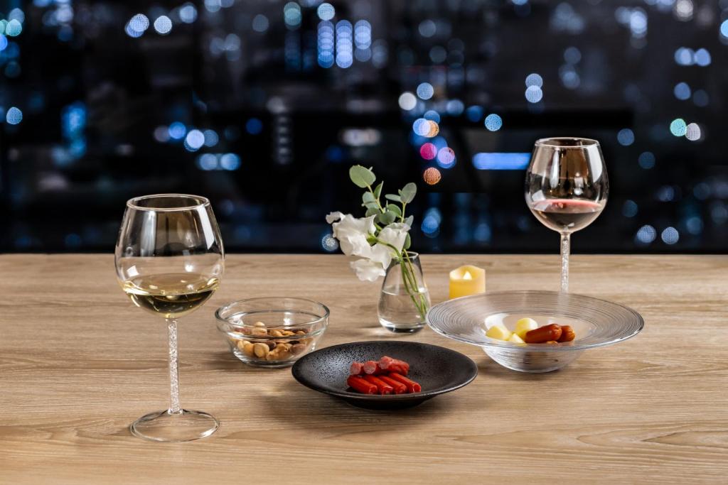 広島市にある三井ガーデンホテル広島のワイン2杯、テーブルの上に盛り付けられた料理