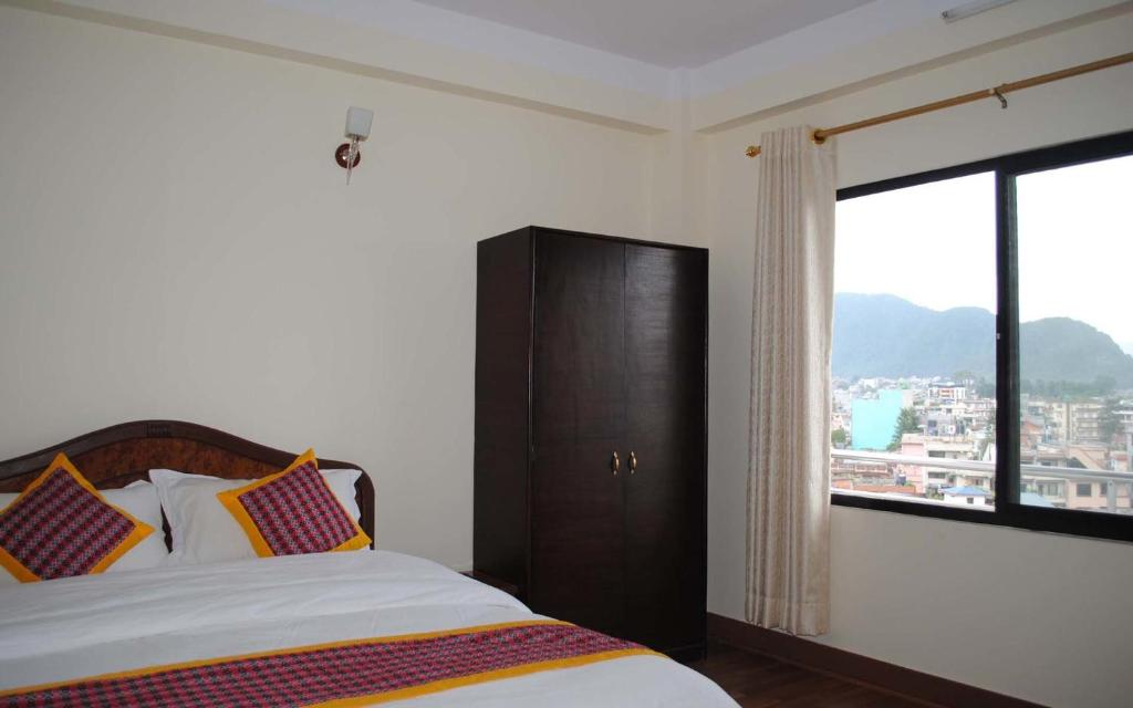 1 dormitorio con cama y ventana grande en Avalon House, en Katmandú