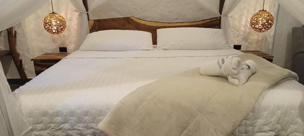 ein Schlafzimmer mit einem weißen Bett mit zwei Handtüchern darauf in der Unterkunft oBeja negra Muki in Pitalito