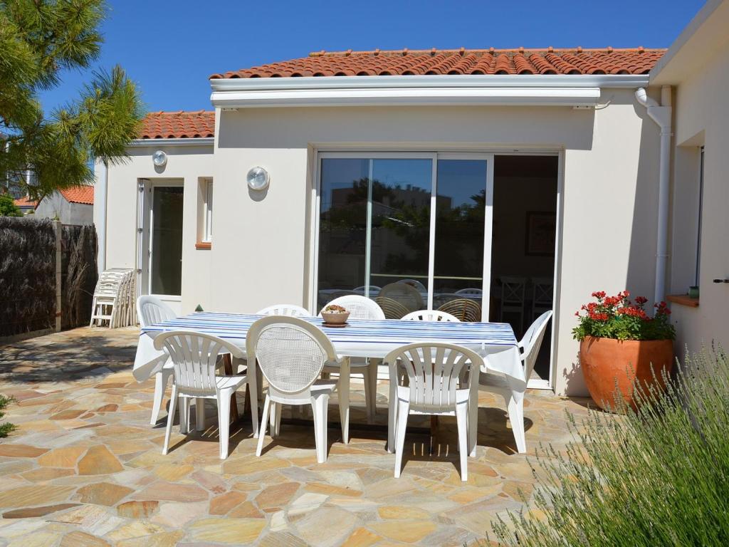 Une table à manger et des chaises sont disponibles sur la terrasse. dans l'établissement Maison bord de mer pour 9 pers. avec terrasse, BBQ, WiFi - à 300m de la plage, tout confort - FR-1-323-501, à Saint-Hilaire-de-Riez