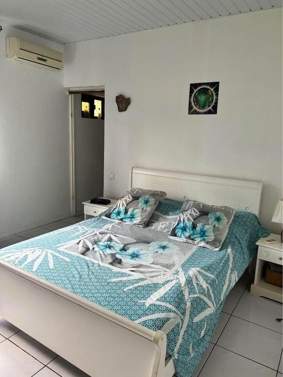 1 dormitorio con 1 cama con edredón azul en CHEZ ANNA & FLORIAN en Tohautu