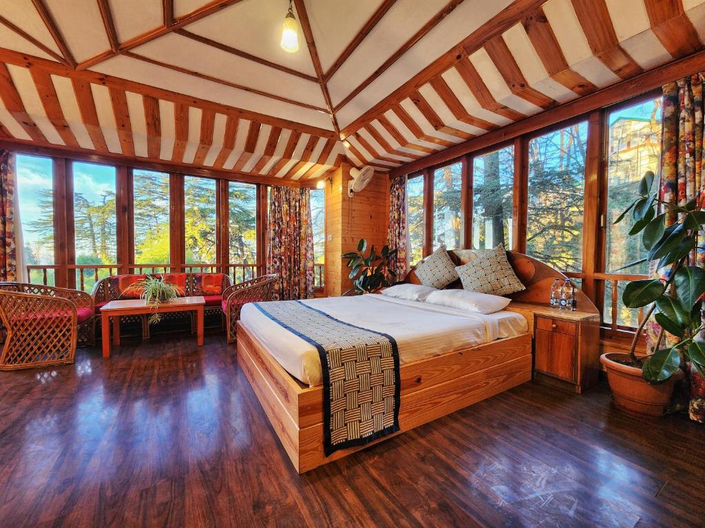 1 dormitorio con 1 cama en una habitación con ventanas en Hotel Pineview Shimla en Shimla
