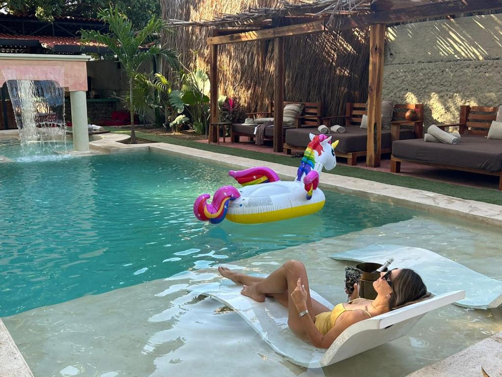 two people laying on rafts in a swimming pool at Historic House Hotel boutique in Mérida