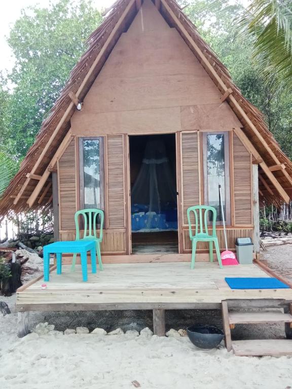 two chairs and a table in front of a house at Or Mandira Homestay in Fam