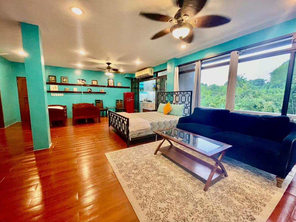 a living room with a blue couch and a table at Ngermid Oasis Large Studio With Kitchen & Scenic Views in Koror