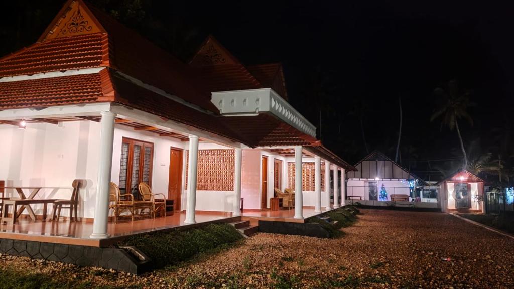 uma casa à noite com uma mesa e cadeiras em The Royal Island em Munroe Island