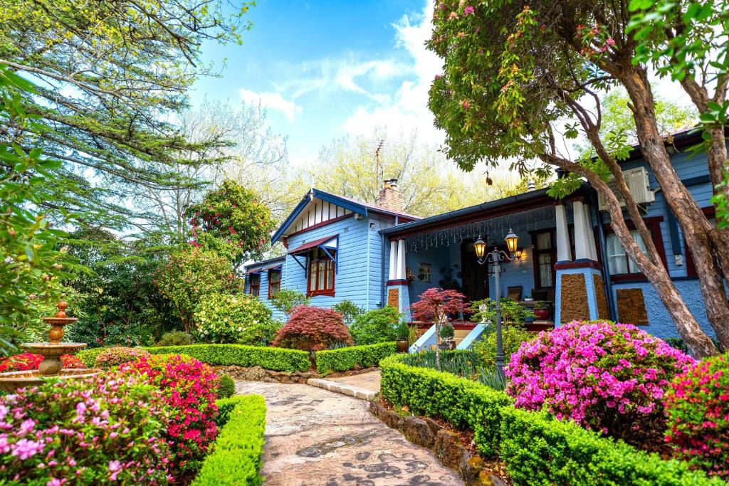 een blauw huis met bloemen ervoor bij KUBBA ROONGA GUESTHOUSE - Boutique Luxury Peaceful Stay & Gardens - Bed & Breakfast in Blackheath