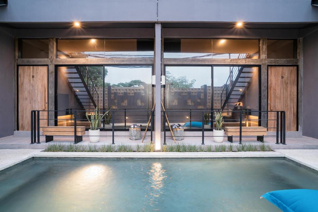a house with a swimming pool in front of a building at Alaya Homes D - Chic Japandi Loft Suite in Seminyak in Seminyak