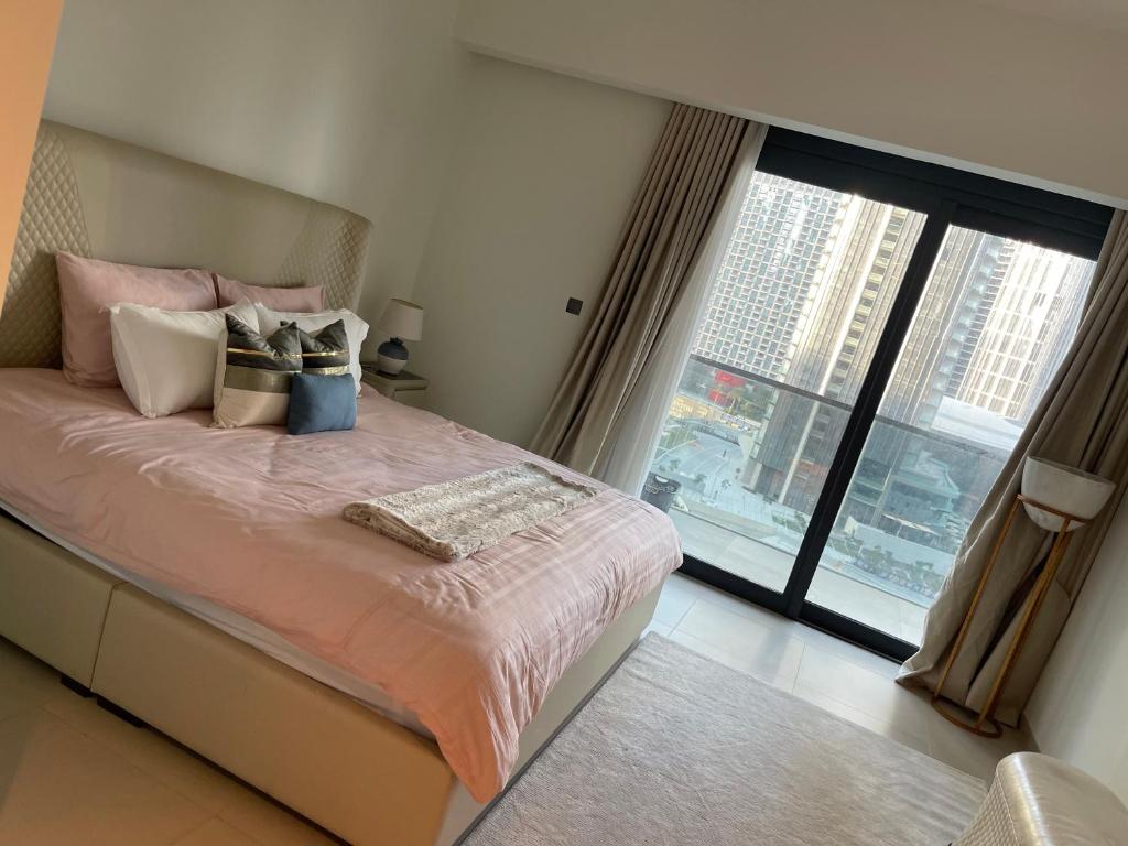 a bedroom with a bed and a large window at 2 Bedrooms Apartment Burj khalifa and fountain view in Dubai