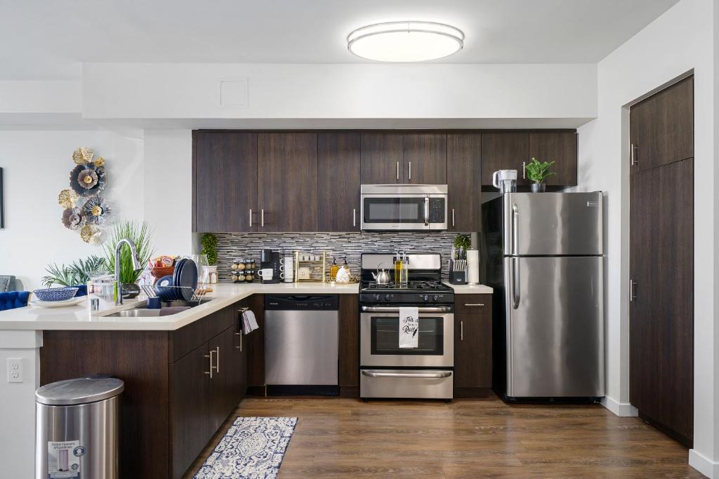 a kitchen with wooden cabinets and stainless steel appliances at DTLA Escape Skyline views with luxury amenities in Los Angeles